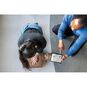 An Instructor Monitoring CPR Compressions on a Little Anne QCPR Enabled Adult CPR Manikin with a Tablet.