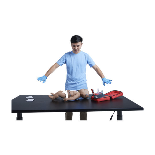 An instructor demonstrating using the AED Trainer on an infant CPR manikin.