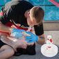 Lifeguard using the BigEasy CPR Rescue Mask Kit on a swimmer next to the pool.