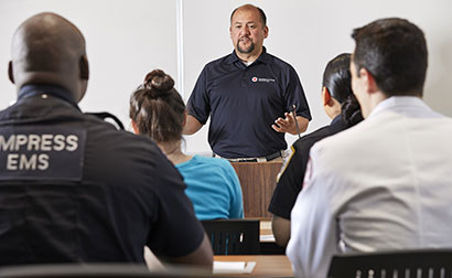 Red Cross Instructor teaching a group of EMTs about Basic Life Support.