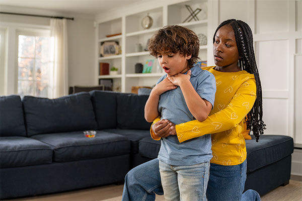 A babysitter helping a choking child by using techniques learned in the Syracuse Babysitter Training course.