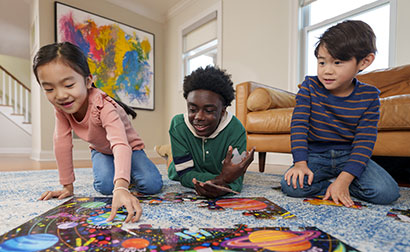 Babysitter and children building a puzzle.