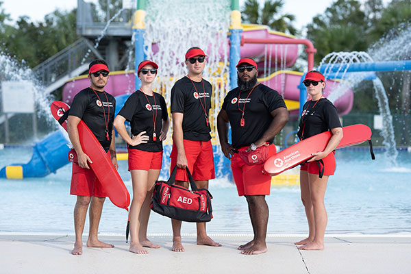 Five Red Cross certified lifeguards with lifesaving equipment in New York.