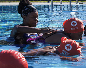 Adults learning to swim from a Red Cross Water Safety Instructor